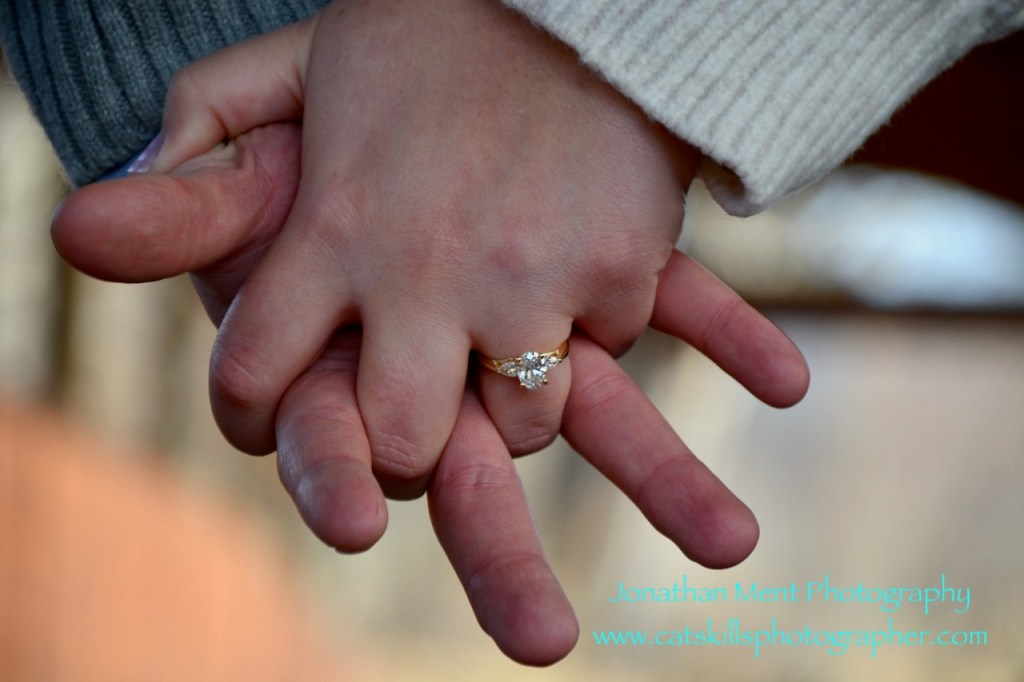 Hands clasped showing engagement ring